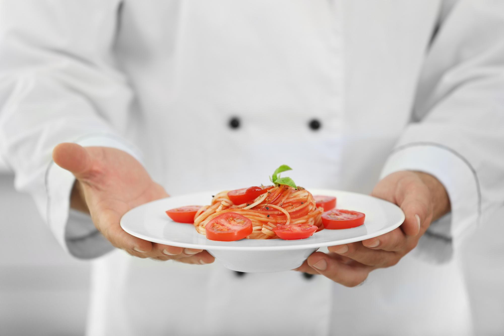 Chef bereitet Gericht in sauberer Küche